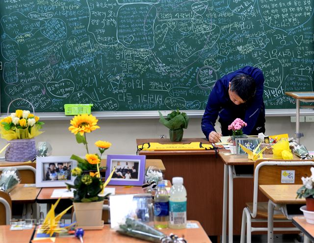 지난 4월 세월호참사로 희생된 안산 단원고 학생의 아버지가 아들의 교실을 찾아 방명록에 글을 쓰고 있다. 신상순 선임기자 ssshin@hankookilbo.com