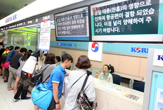 12일 북상하는 태풍 찬홈의 간접 영향으로 비바람이 강하게 몰아치며 제주공항 출발·도착 항공편이 대거 결항한 가운데 관광객과 도외로 나가려는 도민 등이 각 항공사에 운항 여부 등을 문의하고 있다. 연합뉴스