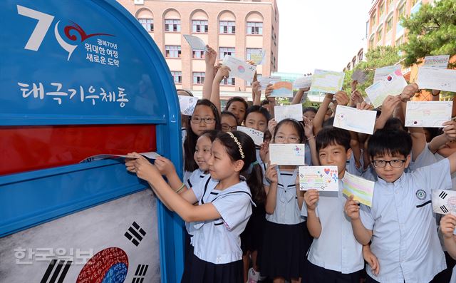 서울 도봉구 쌍문동의 한신초등학교 학생들이 15일 광복 70주년을 한 달 앞두고 독립선언서에 서명한 민족대표 33인에게 고마움을 전하는 손편지를 써 태극기 우체통에 부치고 있다. 배우한기자 bwh3140@hankookilbo.com