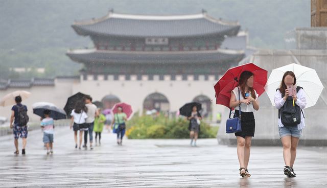 이번주는 기압골과 북상하는 장마전선의 영향으로 전국에 비가 뿌려질 전망이다. 사진은 제9호 태풍 찬홈의 영향으로 전국적으로 제법 많은 양의 비가 내린 12일 오후 서울 종로구 광화문 광장에서 우산을 쓴 시민들이 발걸음을 옮기고 있는 모습. 연합뉴스