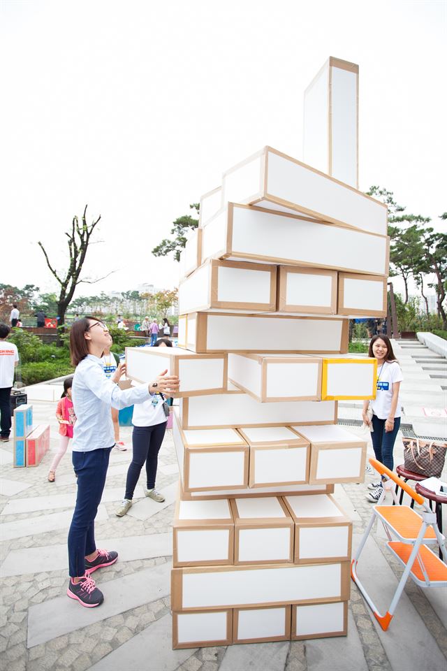 한 시민이 서울시 뚝섬한강공원에 마련된 놀이장인 '노니놀판'에서 박스를 빼서 쌓아 올리는 게임인 대형 젠가를 체험하고 있다. 서울시 제공