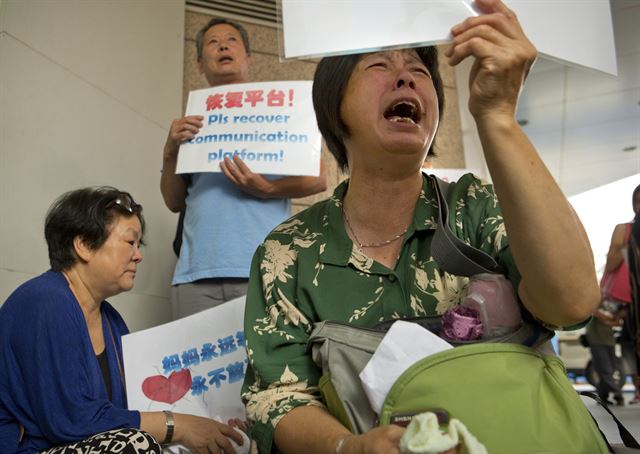 지난달 29일 아프리카 동부 인도양에서 발견된 여객기 잔해가 실종 말레이시아항공 MH370편과 같은 기종인 보잉 777의 부품으로 공식 확인된 가운데, 6일 베이징의 말레이시아 항공 사무소 앞에서 실종자 가족들이 시위를 하고 있다. 베이징=AP 연합뉴스