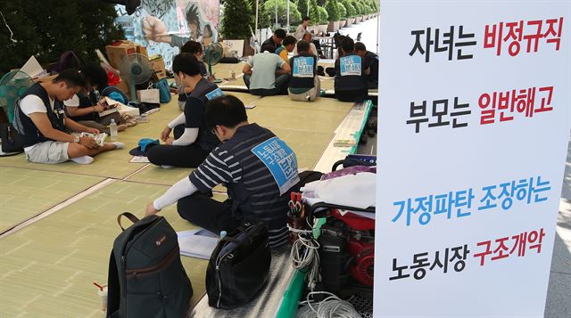 박근혜 대통령의 대국민담화가 발표된 6일 서울 여의도 산업은행 본점 앞에서 천막농성 중인 한국노총 조합원들이 스마트폰으로 중계방송을 보며 대책을 숙의하고 있다. 연합뉴스