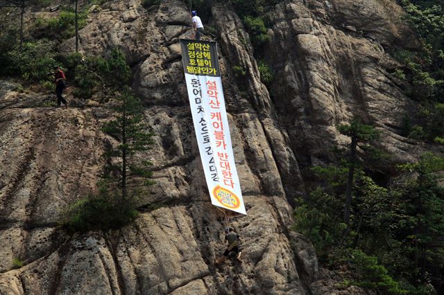 자연공원케이블카반대범국민대책위원회가 7일 한계령 정상에서 개최한 설악산 오색케이블카 반대 고공 퍼포먼스에 참가한 환경운동가들이 피켓과 암벽 현수막으로 케이블카 반대 메시지를 관광객과 국민에게 전달하고 있다. 연합뉴스