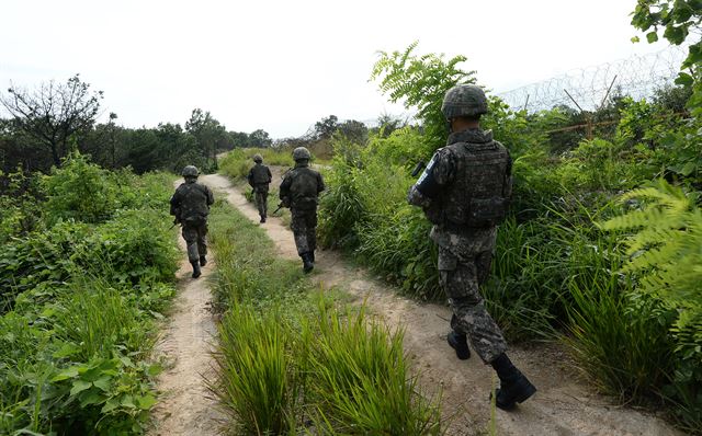 지난 4일 비무장지대(DMZ)에서 발생한 지뢰폭발사고 현장 주변에서 9일 장병들이 무장한 채 수색작전을 하고 있다. 국방부 제공