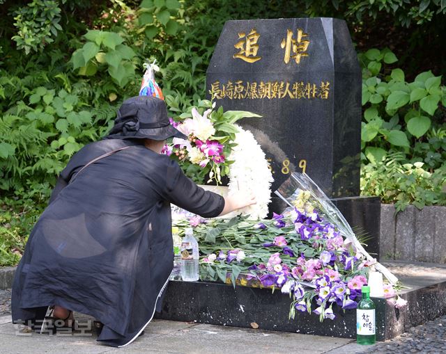 일본 나가사키 원폭자료관에 마련된 조선인희생자 추모비에 한 한국인 추모객이 9일 향을 피우고 있다.