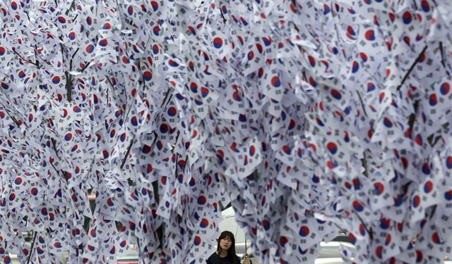 8.15 광복 70주년을 이틀 앞둔 13일 한 여성이 서울 광화문 광장에 조성된 태극기 나무를 바라보고 있다. 서울=AP 연합뉴스