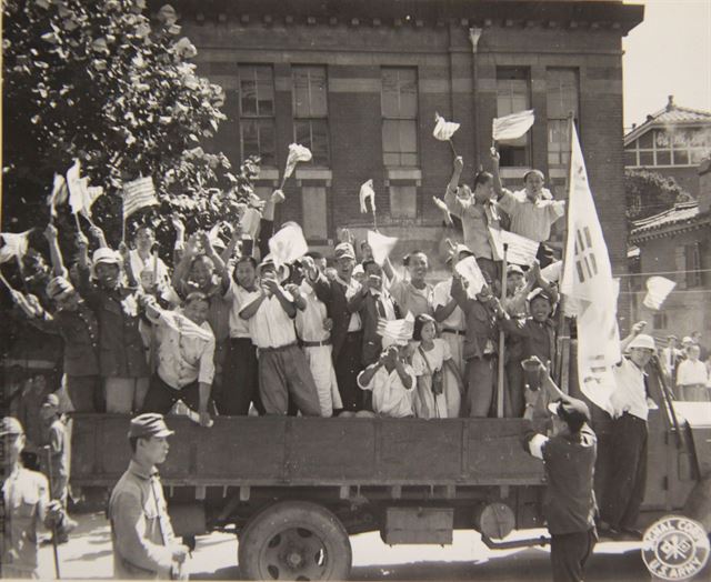 1945년 9월 9일 시민들이 서울역에서 총독부 건물까지 거리행진을 하며 광복의 기쁨을 만끽하고 있다. 손에 태극기와 성조기를 함께 들려 있다. 국사편찬위원회 제공