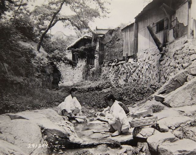 1947년 주부 두 사람이 집 근처 개울에서 가족들의 빨래를 하고 있다. 사진을 찍은 미국병사는 ‘비누가 부족하고 한국 전통의 흰 옷을 빨기 힘든 조건에도 불구하고 이들은 자신들의 원칙을 고수하고 있다’고 평하고 있다. 두 사람은 평생 해온 일이 아무렇지 않다는 듯 쪼그려 앉아 나무방망이로 빨래를 두드리고 있다. 국사편찬위원회 제공