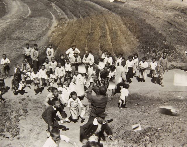 1948년 5월 서울 인근의 한 마을에서 사람들이 L-5 연락기가 뿌린 선거 홍보 전단을 앞다퉈 줍고 있다. 국사편찬위원회 제공