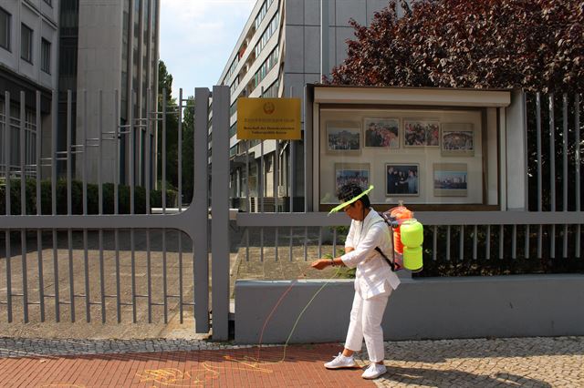 설치미술작가 이은숙씨가 15일 베를린 북한대사관에 도착해 정문 앞에서 실을 풀고 있다. 베를린=연합뉴스