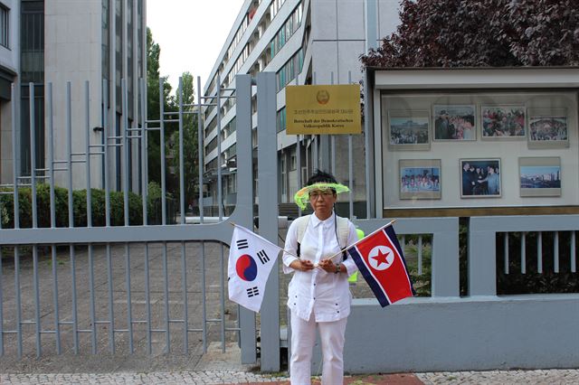 프로젝트를 마친 설치미술작가 이은숙씨가 주독 북한대사관 앞에서 태극기와 인공기를 들어 보이고 있다. 베를린=연합뉴스