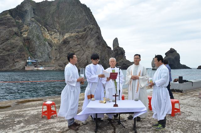 17일 천주교 사제들이 광복 70주년을 맞아 독도 동도 물양장에서 순국선열을 추모하고 평화를 염원하는 미사를 집전하고 있다. 한국천주교 주교회의 제공