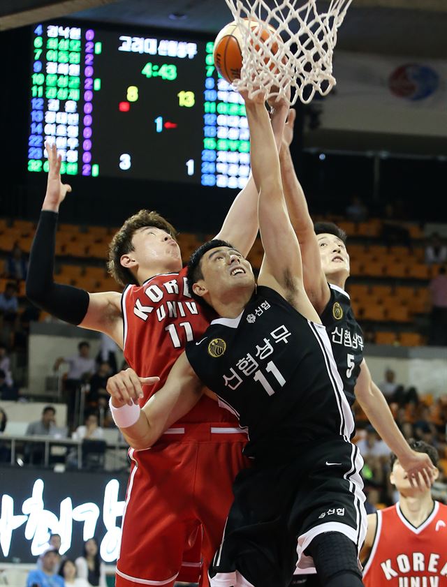 신협 상무 이관희(가운데)와 고려대 이호영(왼쪽)이 19일 서울 송파구 잠실학생체육관에서 열린 2015 KCC 프로-아마농구 최강전 8강전에서 공중 볼을 다투고 있다. 연합뉴스