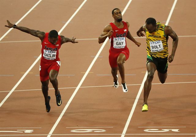 23일 중국 베이징 국립경기장의 제15회 세계육상선수권대회 남자 100m 결승전에서 '번개' 우사인 볼트(29·자메이카, 오른쪽)가 결승선을 통과하고 있다. 볼트는 9초79로, 9초80을 기록한 게이틀린(33·미국, 왼쪽)을 제치고 우승했다. 연합뉴스