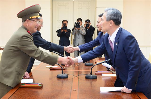 북한의 포격도발로 인한 대치상황과 관련해 남북 고위급 접촉이 타결된 25일 새벽 판문점 평화의 집에서 우리측 대표인 김관진 청와대 국가안보실장, 홍용표 통일부 장관과 북측 대표로 황병서 조선인민군 총정치국장, 김양건 노동당 대남비서가 악수를 하고 있다. 통일부 제공