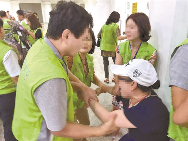 19일 경기 성남시 지하철 분당선 야탑역-버스터미널 연결통로에 행정대집행을 나온 분당구청 직원들이 집행에 저항하는 상인을 막아서고 있다. 구청은 이달 1일, 19일, 25일 세 차례의 행정대집행을 통해 총 2억여원 상당의 물품을 압수했다.