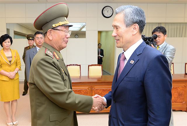 김관진 국가안보실장(오른쪽)과 북측 황병서 군 총정치국장이 25일 오전 판문점에서 '무박4일' 마라톤 협상을 마치고 악수하고 있다. 통일부 제공