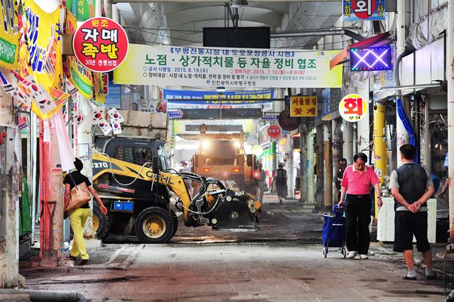 쓰레기와 가판대 등으로 비좁았던 인천 부평종합시장에서 도로 포장공사가 이뤄지고 있다. 부평구청 제공