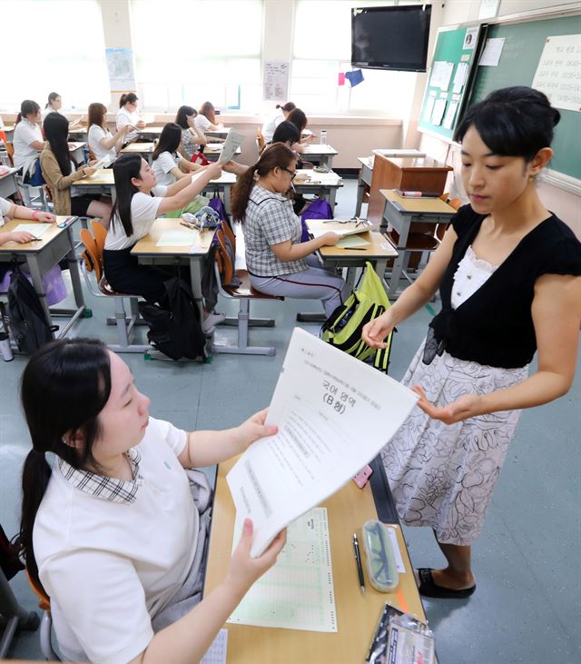 고등학생 전국연합학력평가 및 대학수학능력시험 모의평가가 시행된 2일 오전 서울 신정동 금옥여고에서 학생들이 교사로부터 시험지를 받고 있다. 연합뉴스