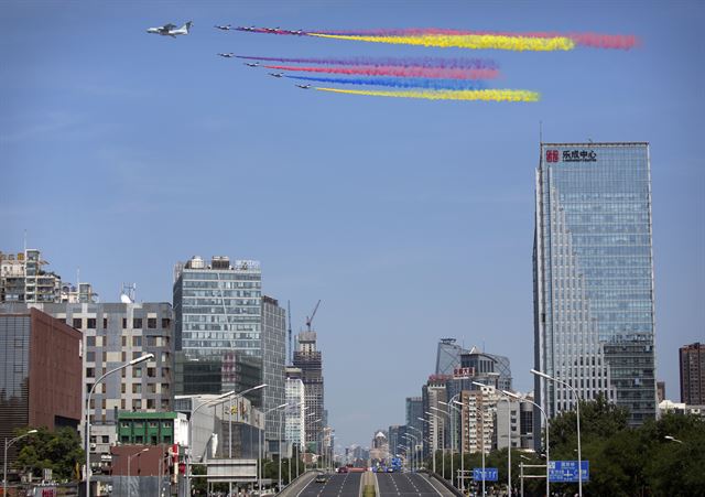 3일 중국 베이징 톈안먼 광장에서 '중국인민의 항일전쟁 승리 및 세계 반(反)파시스트 전쟁 승리 70주년' 을 맞아 사상 최대 규모의 열병식이 열려 축하비행에 나선 중국 전투기가 형형색색의 연기를 뿜으며 베이징 중앙 업무지구 상공을 비행하고 있다. 베이징=신화 연합뉴스