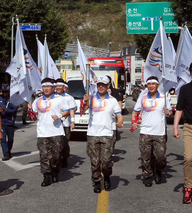 문경 세계군인체육대회 성화 봉송주자인 서정열(가운데) 육군 7사단장이 22일 강원 화천군 화천읍에서 성화를 들고 뛰고 있다. 화천=연합뉴스