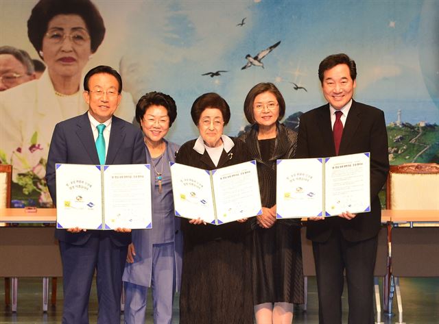 이희호(가운데) 여사와 김관용 경북지사 부부(왼쪽), 이낙연 전남지사 부부가 23일 경북 경주세계문화엑스포장 문화센터에서 '영호남 상생 장학기금' 기탁증서를 들고 환하게 웃고 있다. 경북도 제공