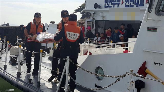 4일 오후 인천시 중구 팔미도에서 유람선 접안 중 발생한 충격으로 다친 승객을 해경 대원들이 이송하고 있다. 인천해경 제공