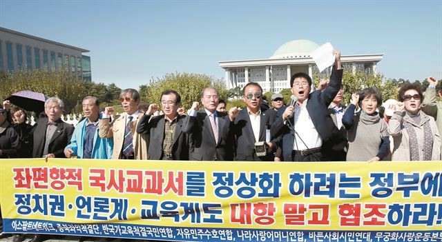 정부가 한국사 교과서 국정화 방침을 발표한 12일 종북좌익척결단, 반국가교육척결국민연합 등 보수단체 회원들이 국회 정문 앞에서 정부 지지 발언을 하고 있다. 연합뉴스