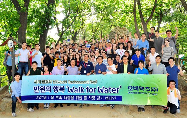 오비맥주 직원들이 올해 6월 서울 우면산에서 열린 사회공헌 프로그램 ‘만원의 행복, 물 사랑 걷기’에 참가한 뒤 기념 촬영을 하고 있다. 오비맥주 제공