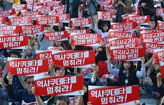 17일 오후 서울 종로구 세종로공원에서 열린 '한국사교과서 국정화 저지 국민대회'에서 참가자들이 피켓을 들고 구호를 외치고 있다. 연합뉴스