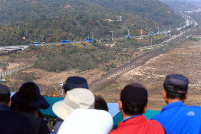 금강산에서 열리는 남북 이산가족 상봉행사에 참가하는 남측 이산가족들이 방북한 20일 오전 통일전망대를 찾은 관광객들이 동해선 육로를 통해 방북하는 상봉단 버스를 바라보고 있다. 2015.10.20 연합뉴스