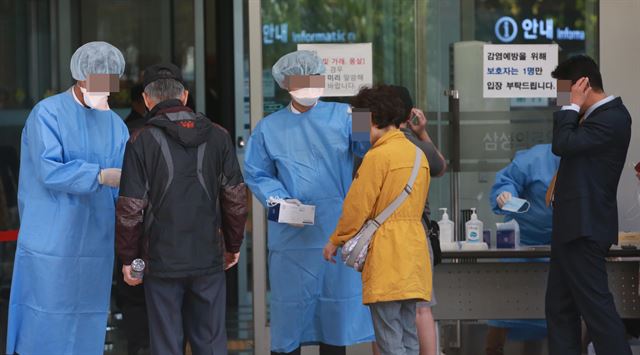 13일 강남구 일원동 삼성서울병원 입구에서 병원 관계자가 출입자를 상대로 체온을 재고 있다. 연합뉴스