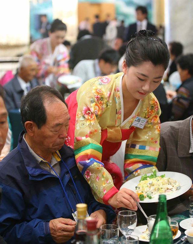 제20차 이산가족 상봉행사 1회차 둘째날인 21일 오전 금강산호텔에서 열린 공동중식 만찬에서 북측 접대원 여성들이 상봉 가족들에게 음식을 대접하고 있다. 금강산=연합뉴스