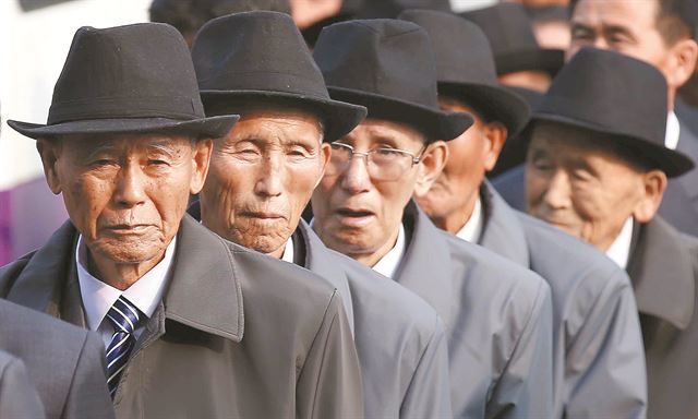 이산가족 상봉행사 둘째날인 21일 오전 북측 가족들이 개별상봉을 위해 금강산호텔에 들어서고 있다. 북한 당국이 제공한 것으로 보이는 같은 종류의 상의에다 중절모까지 통일한 차림새가 이채롭다. 금강산=연합뉴스