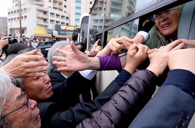 남북 이산가족 1차 상봉행사는 22일 금강산 이산가족면회소에서 진행된 작별상봉을 끝으로 막을 내렸다. 북측 가족들이 탄 버스가 출발하기 직전 남측 가족들이 손을 놓지 못한 채 눈물로 마지막 배웅을 하고 있다. 금강산=사진공동취재단