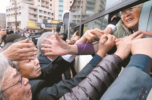 남북 이산가족 1차 상봉행사는 22일 금강산 이산가족면회소에서 진행된 작별상봉을 끝으로 막을 내렸다. 북측 가족들이 탄 버스가 출발하기 직전 남측 가족들이 손을 놓지 못한 채 눈물로 마지막 배웅을 하고 있다. 금강산=사진공동취재단