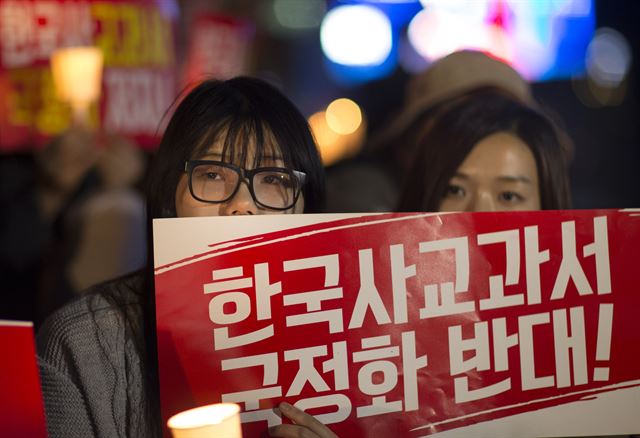 지난 23일 오후 서울 중구 파이낸스센터 앞에서 열린 한국사교과서 국정화 반대 국민촛불대행진에서 참석자들이 정부의 한국사교과서 국정화 결정을 반대하는 내용이 적힌 종이를 들고 있다. 연합뉴스