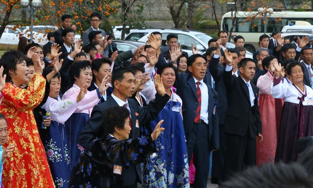 제20차 이산가족 상봉행사 2회차 마지막인 26일 오전 금강산호텔에서 열린 작별상봉이 끝난 뒤 북측 가족들이 버스에 탑승한 남측 가족들을 배웅하며 '우리는 하나'를 부르고 있다.금강산=연합뉴스