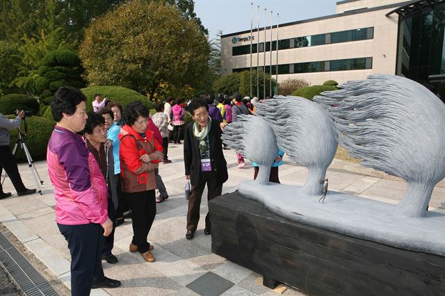 시민들이 대구텍 야외 잔디광장에서 조각작품을 감상하고 있다./2015-10-28(한국일보)