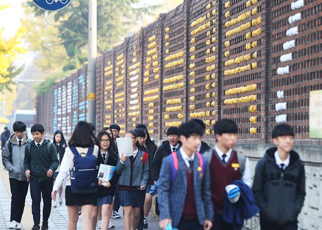 2016학년도 대학수학능력시험을 일주일 앞둔 5일 오전 경기도 수원시 효원고등학교 담에 새겨진 '수능대박'글씨 옆으로 학생들이 등교 하고 있다. 연합뉴스