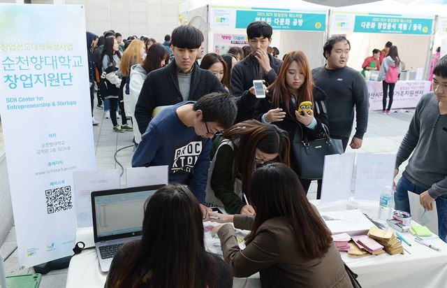 순천향대가 운영중인 '기업가 정신주간'의 창업장터에 참가한 학생들이 대학생 창업인식에 관한 설문조사에 서명을 하고 있다. 순천향대 제공/2015-11-05(한국일보)