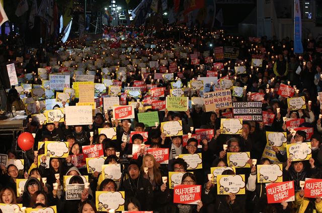 지난달 31일 오후 서울 청계광장에서 국정화저지네트워크 주최로 열린 '역사교과서 국정화 저지를 위한 3차 범국민대회'에서 참가자들이 촛불을 들고 구호를 외치고 있다. 연합뉴스