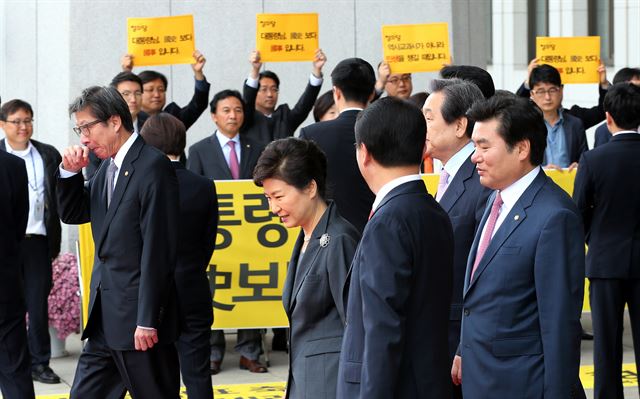 박근혜 대통령이 지난달 27일 오전 국회에서 시정연설을 끝내고 김무성 새누리당 대표등 지도부의 안내를 받은며 퇴장하고 있다. 박근혜 대통령 뒤로 정의당 의원단이 국정화 반대 피켓시위를 벌이고 있다. 고영권기자 youngkoh@hankookibo.com