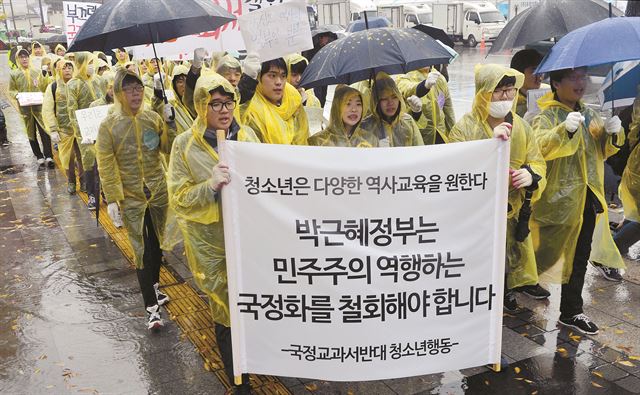 많은 비가 내린 7일 오후 한국사교과서 국정화에 반대하는 청소년들이 서울 종로구 정부서울청사 앞에서 기자회견을 연 뒤 광화문광장을 향해 행진하고 있다. 뉴시스