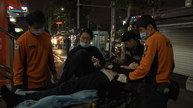 6일 오후 서울 신림동의 한 건물 아래에서 본보 정준호(가장 왼쪽) 기자가 관악소방서 구급대원들과 함께 환자를 들것에 싣고 구급차로 옮기고 있다. 원민우 인턴PD minoo4170@gmail.com