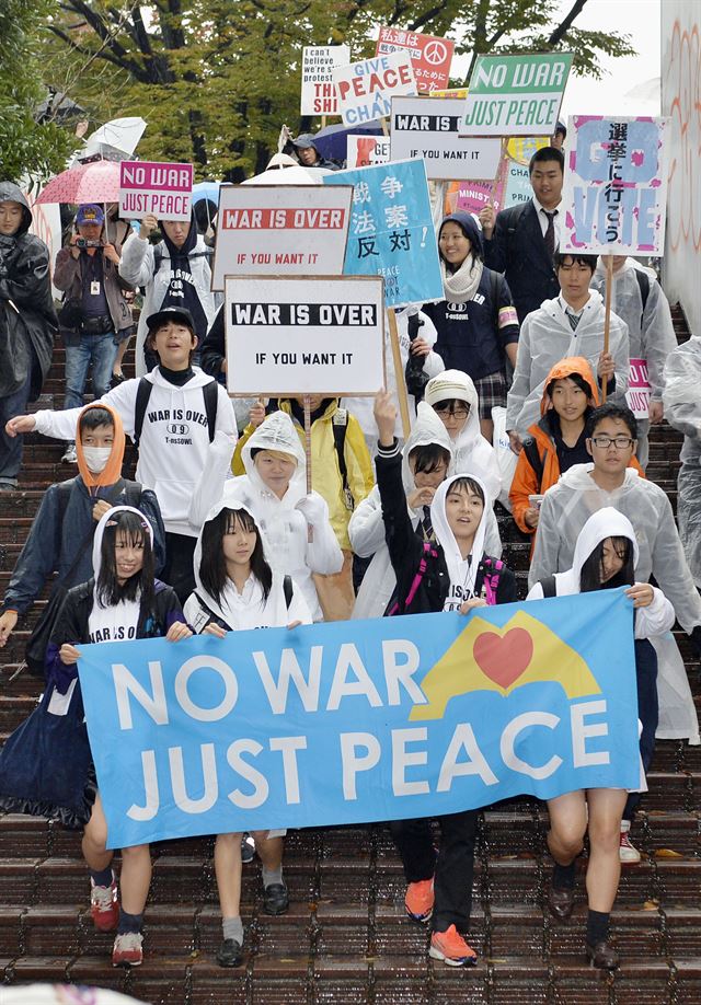 8일 오후 일본 도쿄도(東京都) 시부야(澁谷)구에서 비가 내리는 가운데 안보법률 반대 시위를 벌이고 있는 일본 고교생들. 도쿄=연합뉴스