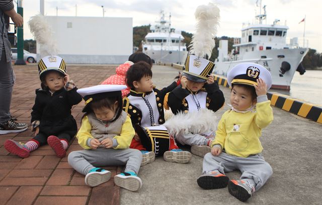 11일 오전 ‘제70주년 해군창설 기념식’이 열린 경남 창원시 해군사관학교를 방문한 아이들이 해군 복장을 한 채 바닥에 앉아 즐거운 한때를 보내고 있다. 창원=연합뉴스