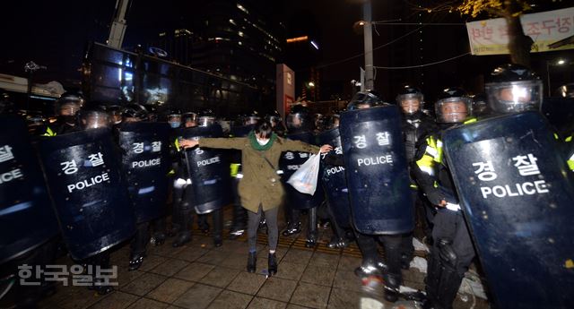 [저작권 한국일보]14일 오후 서울 중구 시청 세종대로에서 열린 민중총궐기대회에서 경찰들이 참가자들을 진압하는 과정에서 충돌을 빚자, 한 여성참가자가 "서로 싸우지 말라"며 경찰들 앞을 가로막고 있다. 민주노총, 전농 등 참가단체들은 집회에서 정부가 추진하는 노동개혁과 역사 교과서 국정화 정책을 규탄하고 청년실업, 쌀값 폭락, 빈민 문제 등의 해결책 마련을 요구했다. 서재훈기자 spring@hankookilbo.com