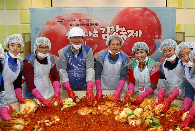 지난 14일 삼성디스플레이 박동건 대표이사(왼쪽 세번째)를 비롯, 임직원 가족 등 500여명이 '제11회 사랑나눔 김장축제'에 참가해 김장을 담그고 있다. 삼성디스플레이 제공